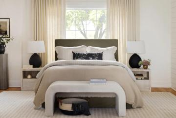 Serene organic modern bedroom with neutral palette, olive upholstered headboard, cream bedding, and curved white bench creating calm, layered aesthetic.
