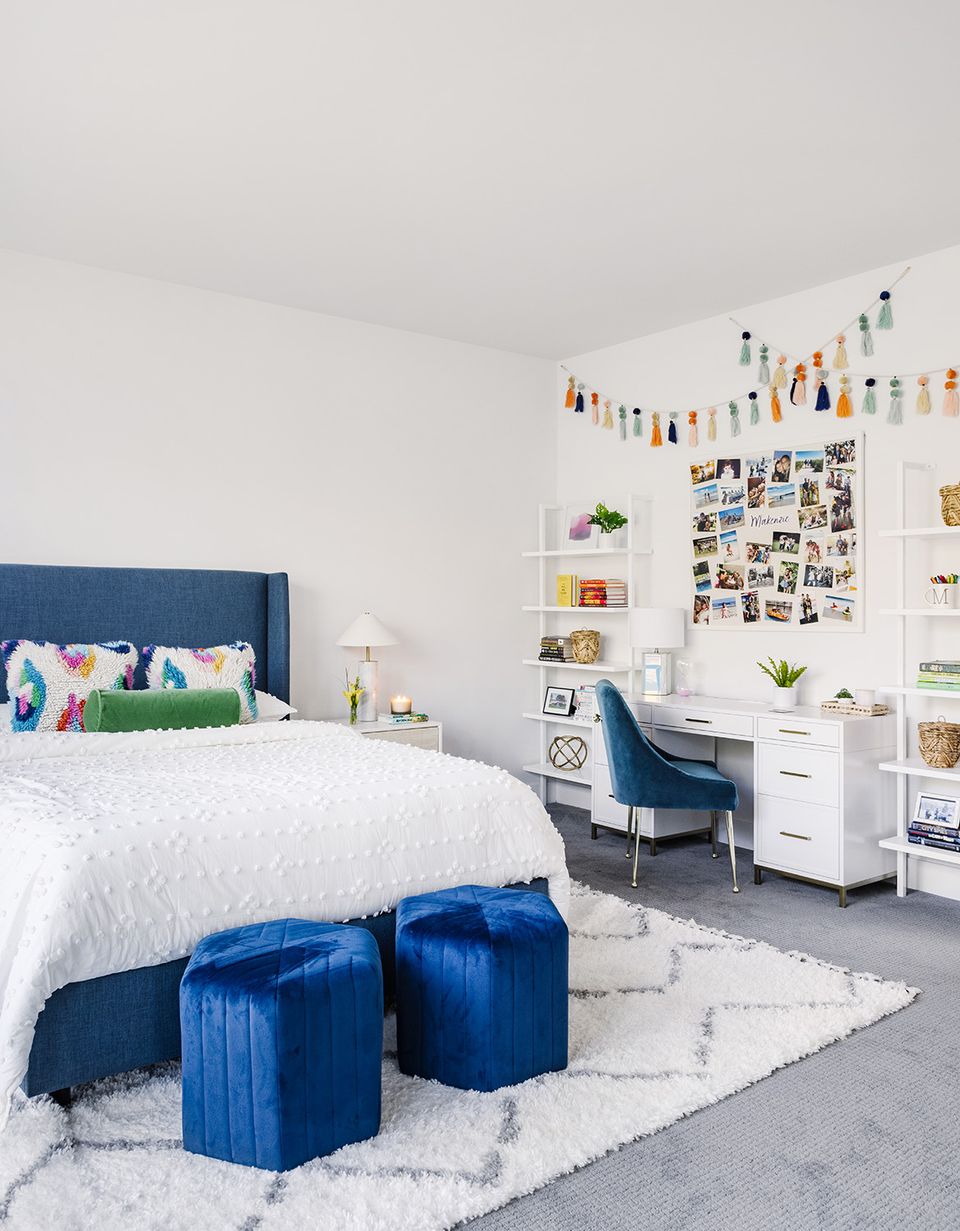 Modern blue and white kid's bedroom with gallery wall, organizational shelving, and vibrant accent pieces