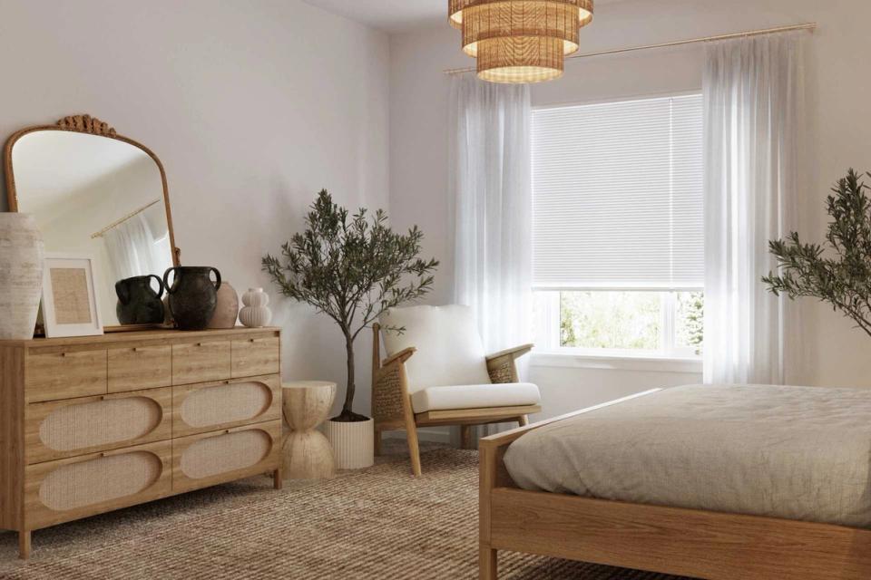 Light-filled organic modern bedroom with wood dresser, arched mirror, greenery, and minimalist aesthetic