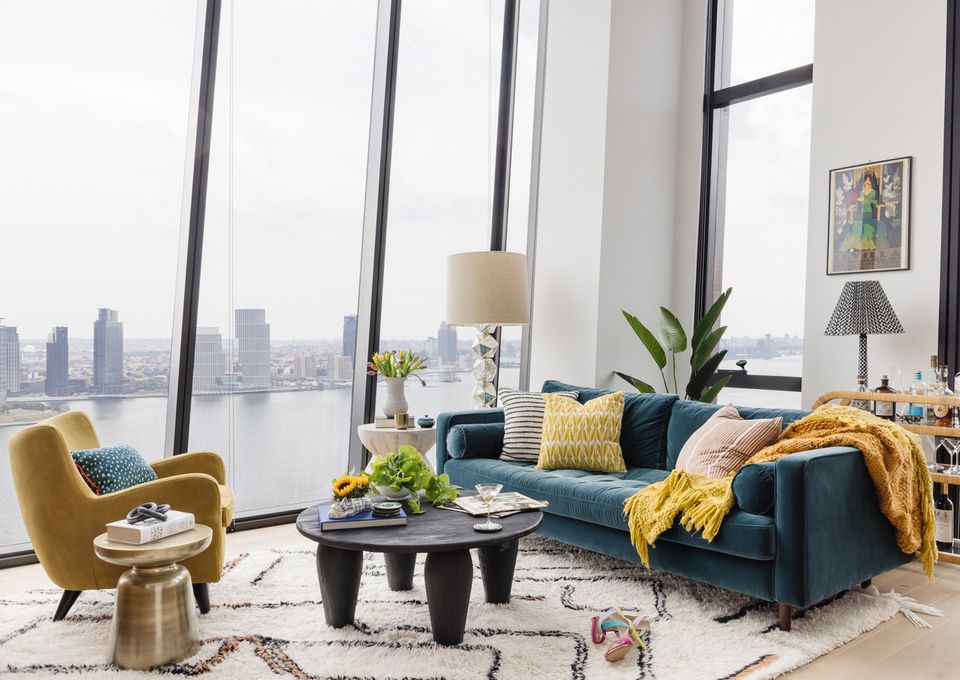 Modern Manhattan loft with navy sofa, mustard accents, city skyline views, and minimalist palette