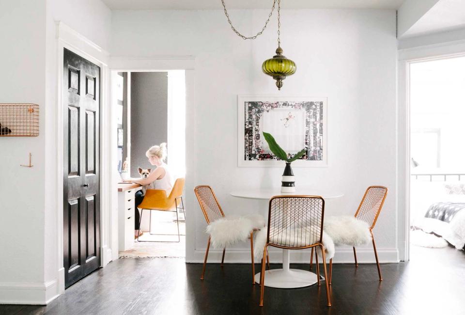 Modern dining nook with warm wood accents, neutral upholstered chairs, vintage pendant, and bright transitional style.