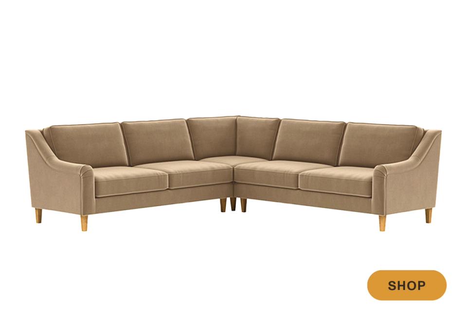 Mid-century modern tan sectional with tapered wood legs and warm neutral palette