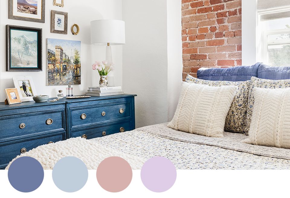 Serene coastal bedroom with navy dresser, soft pastels, and exposed brick accent wall