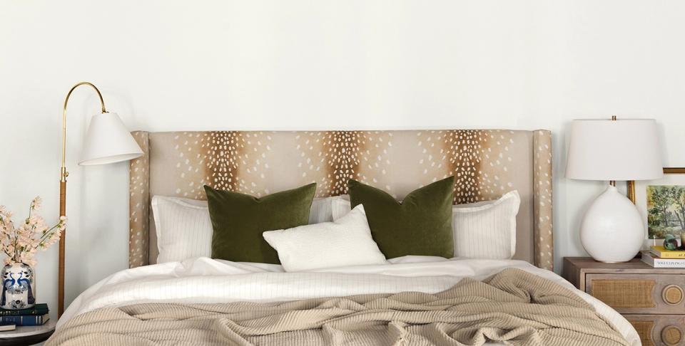 Serene bedroom with leopard print headboard, olive pillows, and warm neutral bedding