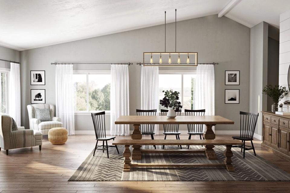 Farmhouse dining room with warm wood table, spindle chairs, neutral walls, natural light, and hanging pendant fixture