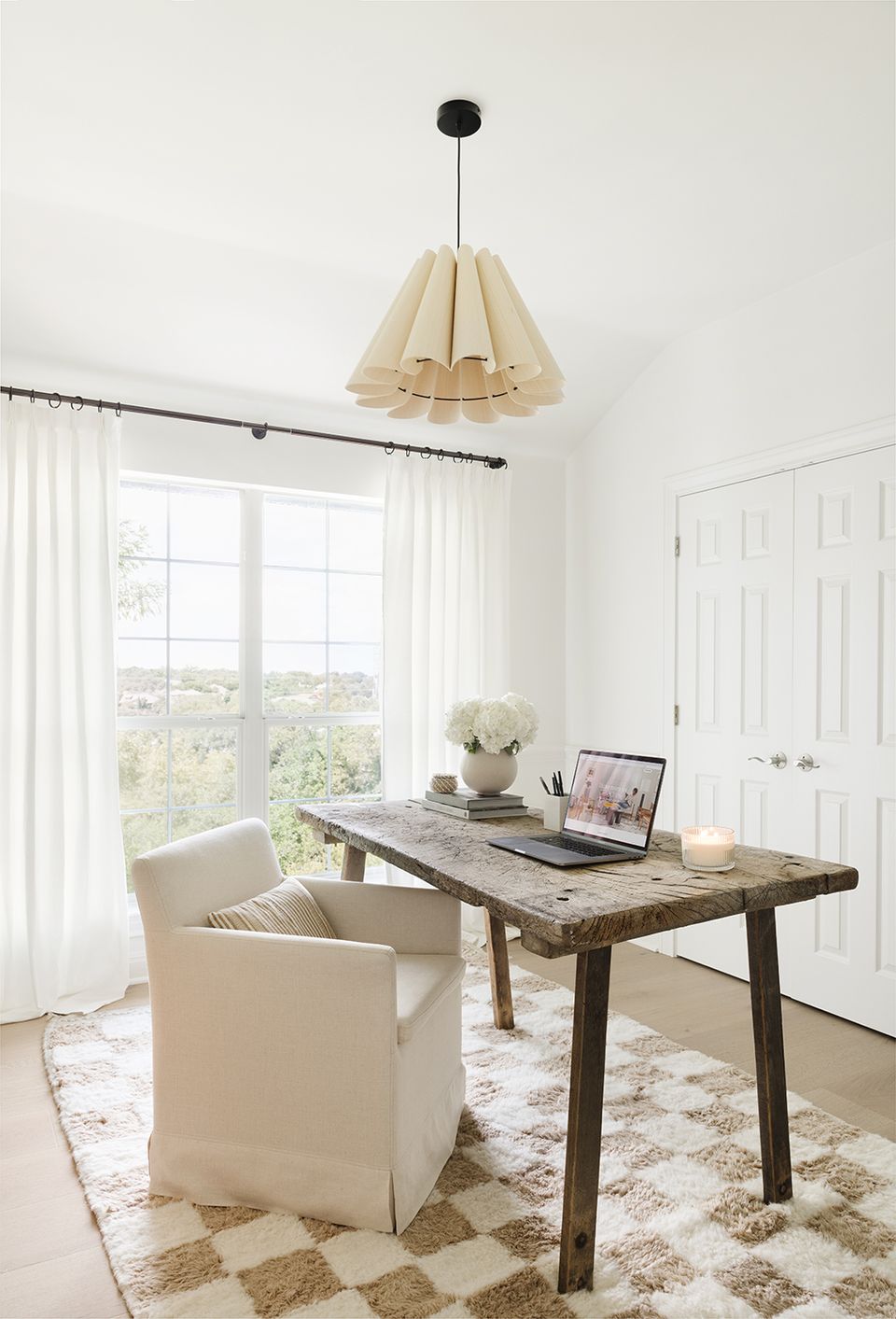 Scandinavian home office with natural wood desk, cream linen chair, pleated pendant light, and neutral palette
