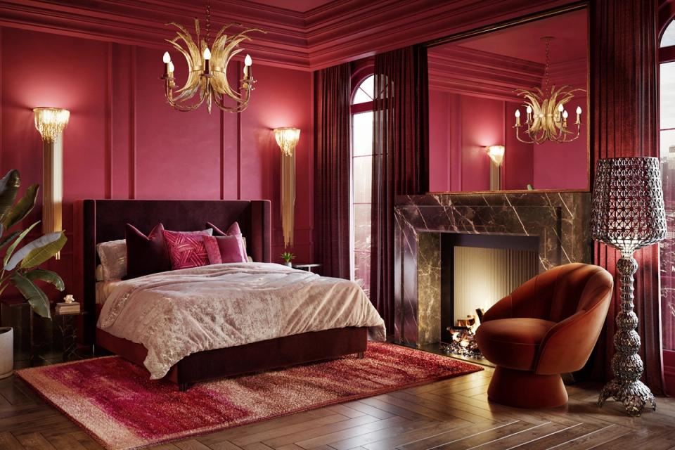 Glamorous magenta bedroom with black velvet bed, brass chandeliers, and jewel-toned velvet seating