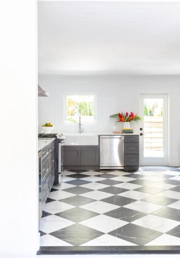Contemporary kitchen with charcoal cabinetry, white subway tile, and classic black-and-white diamond flooring
