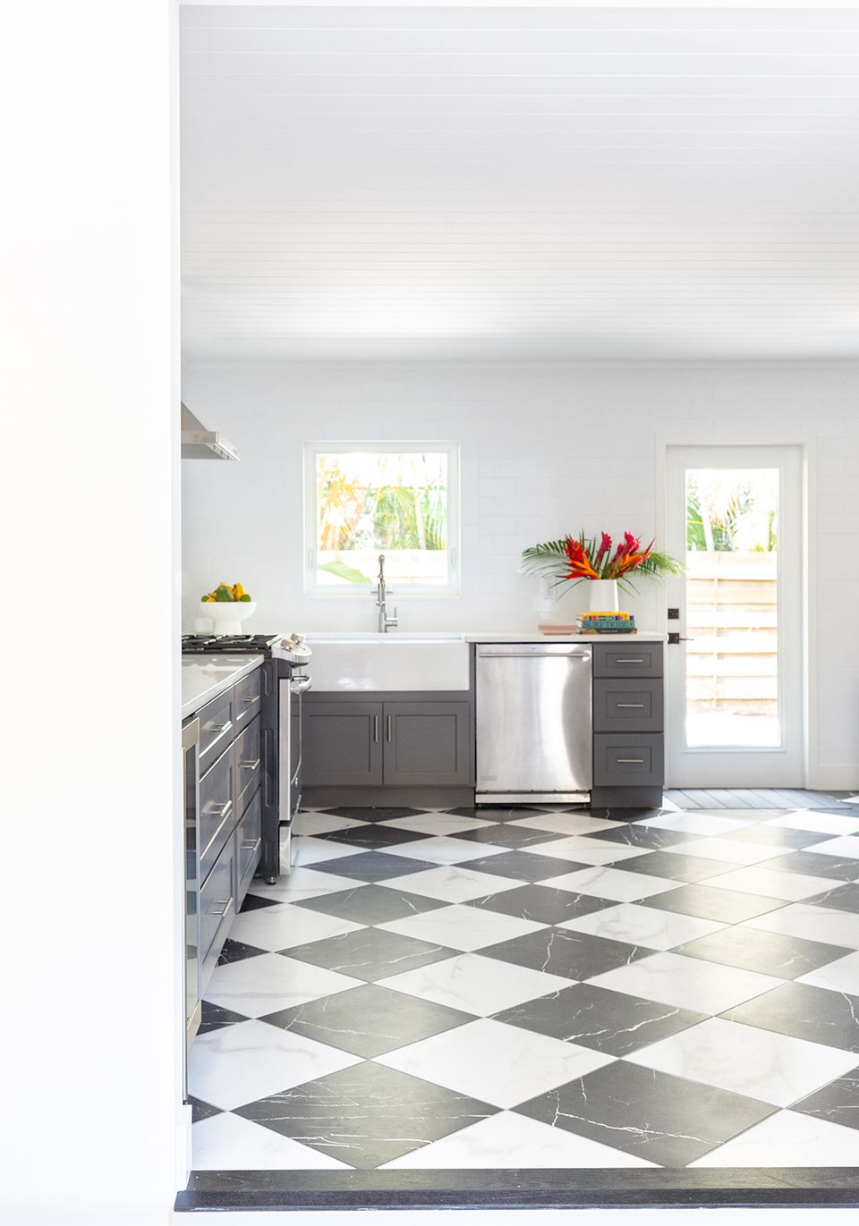 Contemporary kitchen with charcoal cabinetry, white subway tile, and classic black-and-white diamond flooring