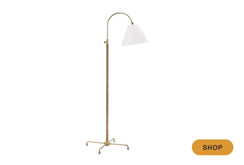 Mid-century modern brass arc floor lamp with minimalist white shade and tripod base