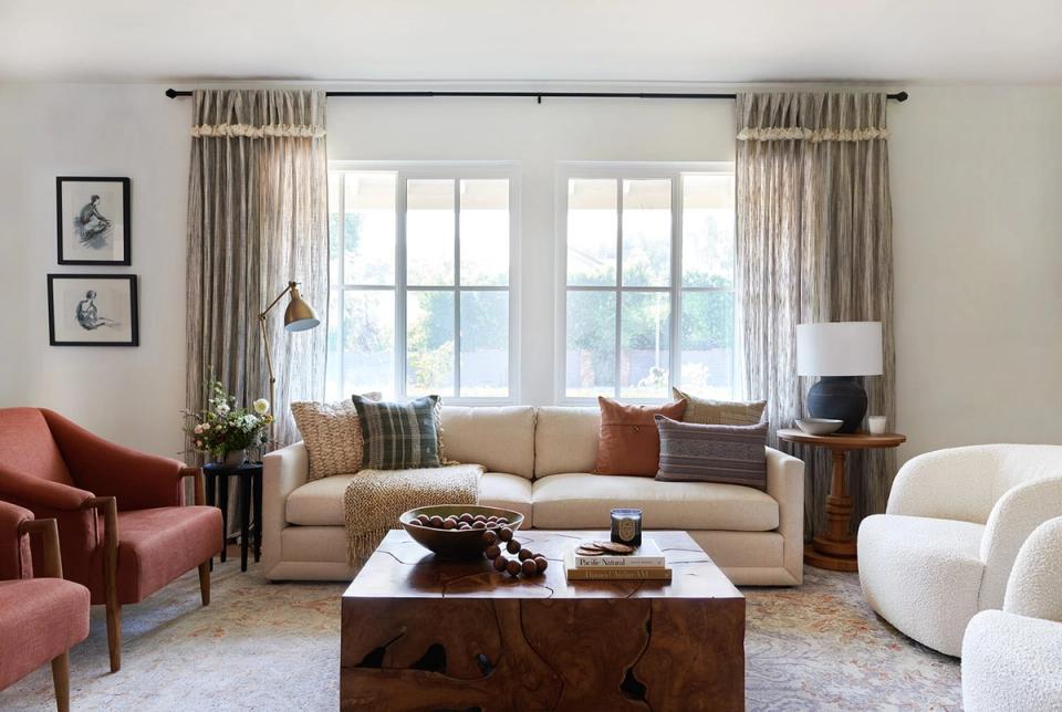Contemporary living room blending warm terracotta accents, neutral seating, and natural light for balanced sophistication.