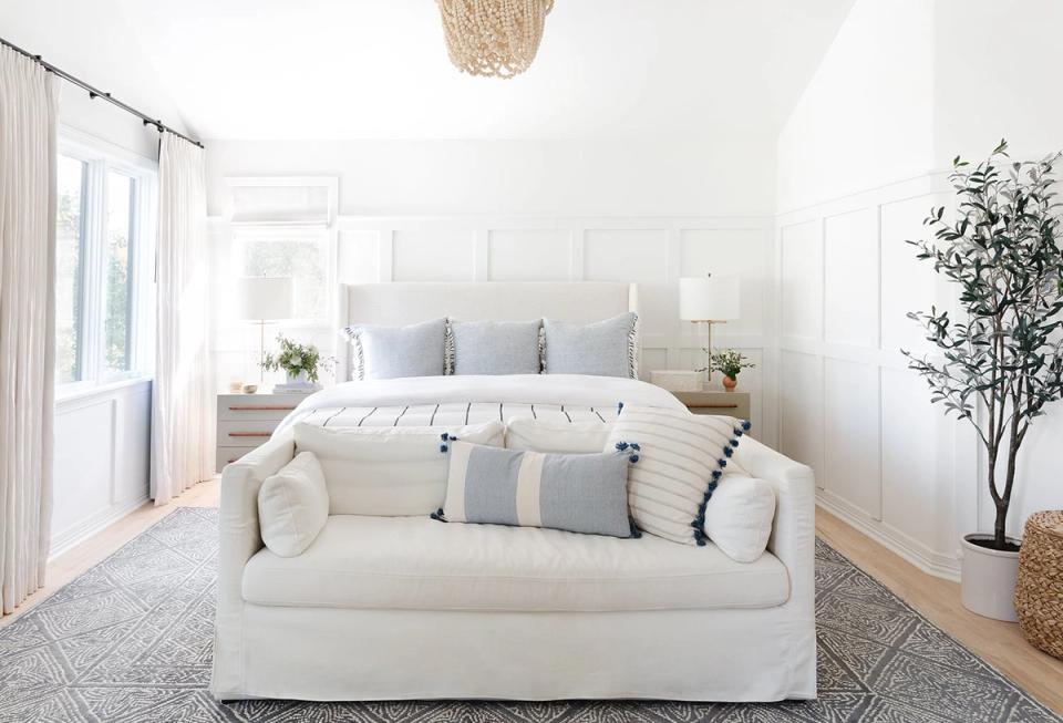 Light-filled modern bedroom with cream upholstered bed, natural materials, and balanced layout