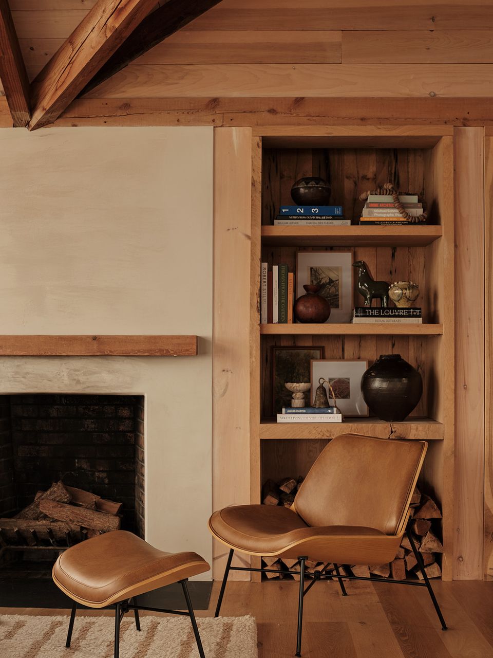 Rustic mid-century interior with wooden built-in shelving and cognac leather chair
