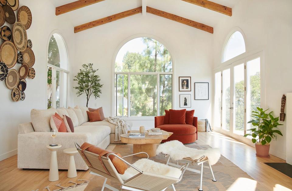 Mediterranean living room with warm wood beams, terracotta accents, and abundant natural light