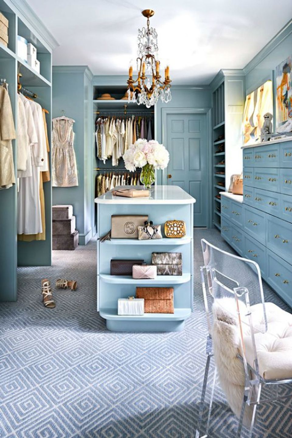 Luxe teal closet with crystal chandelier, island storage, and sophisticated neutral palette