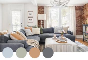 Contemporary living room blending warm caramel accents with charcoal sectional and exposed brick, creating cozy modern industrial atmosphere.