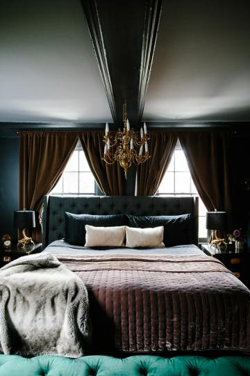 Dramatic maximalist bedroom with black walls, gold chandelier, bronze curtains, and moody elegance
