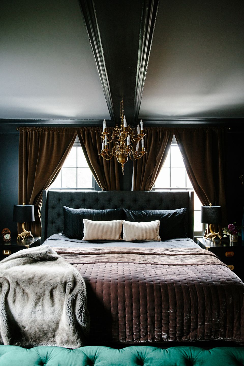 Dramatic maximalist bedroom with black walls, gold chandelier, bronze curtains, and moody elegance