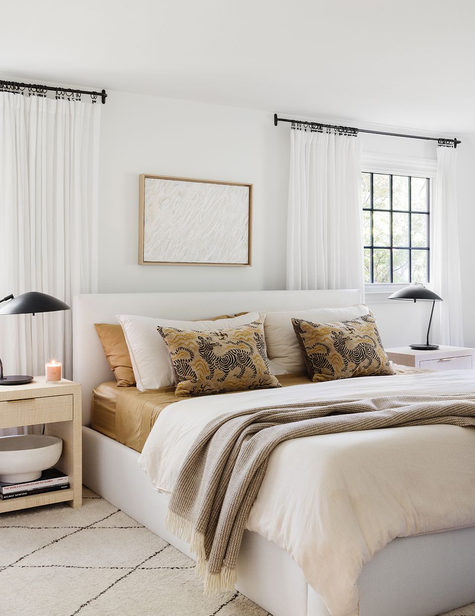 Modern farmhouse bedroom with golden botanical pillows, taupe accents, and black vintage sconces
