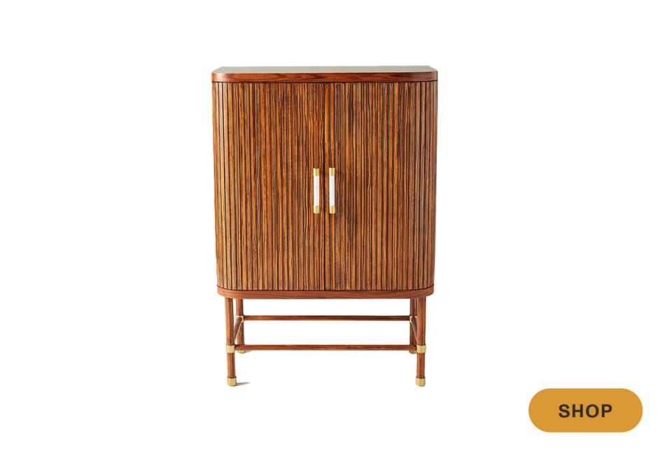 Mid-century modern cabinet in warm walnut wood with vertical ribbed detailing and tapered legs