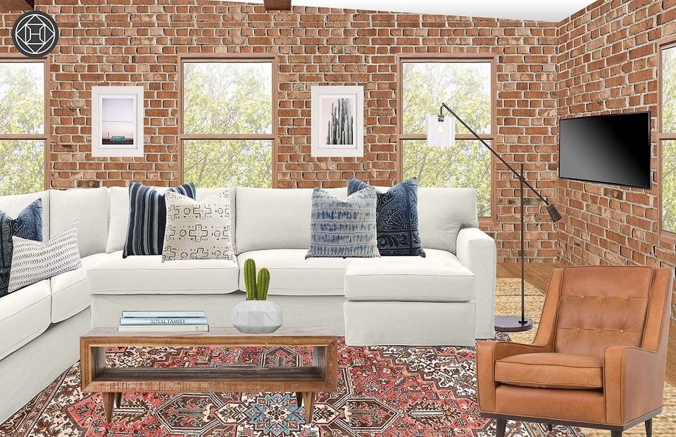 Industrial loft with exposed brick, cream sectional, cognac leather chair, and warm earthy tones