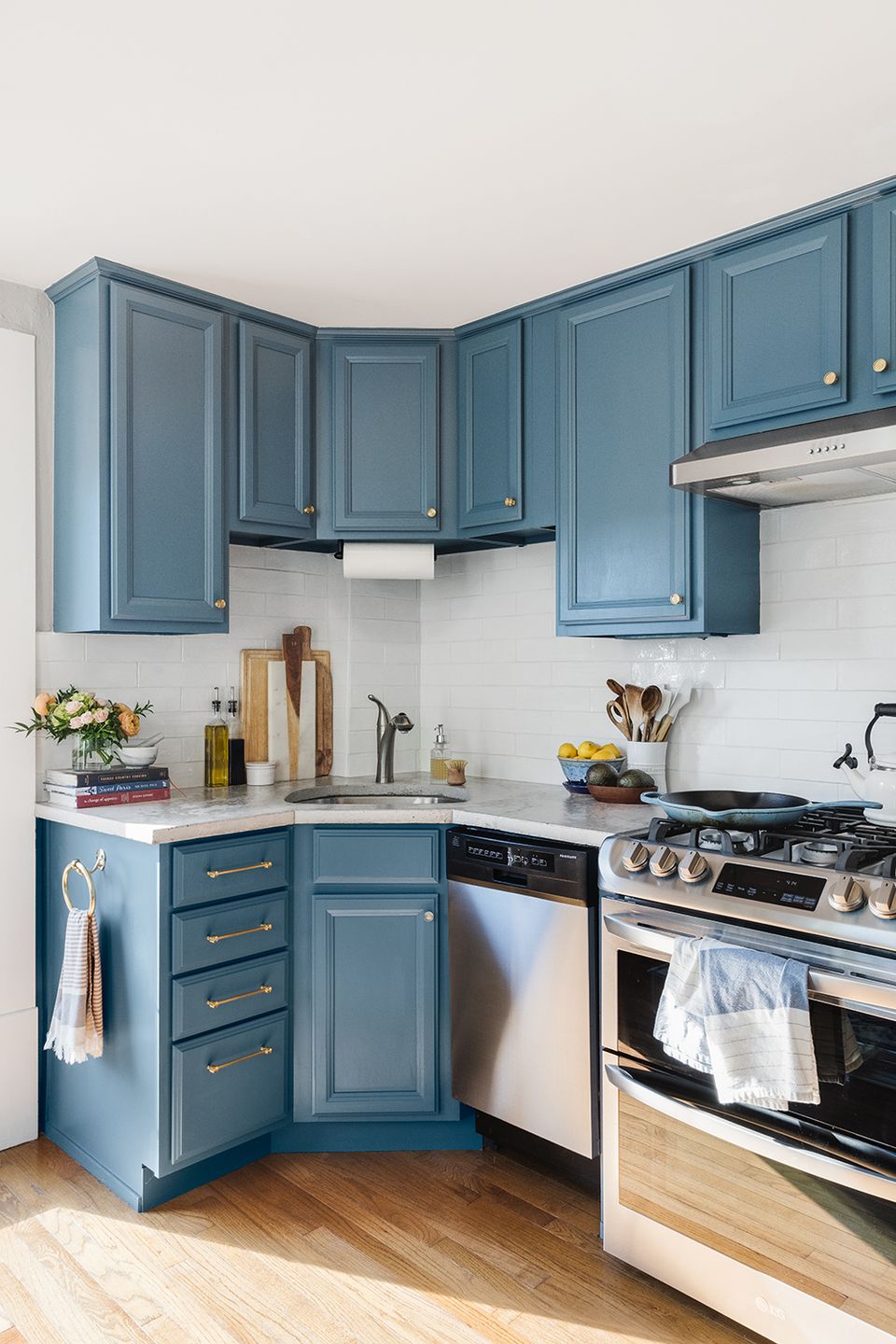 Compact kitchen with slate blue cabinetry, white subway tile, and transitional styling