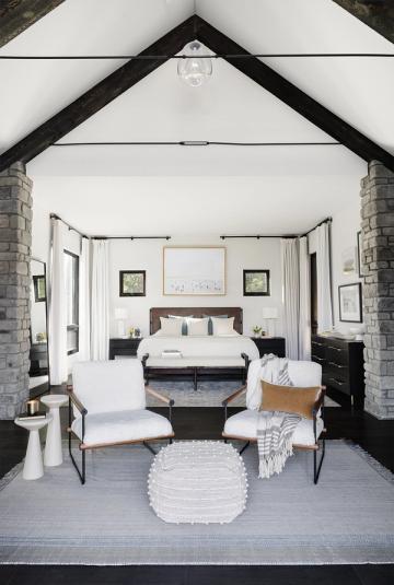 Modern farmhouse bedroom with vaulted ceilings, black-and-white palette, and contemporary minimalist furnishings
