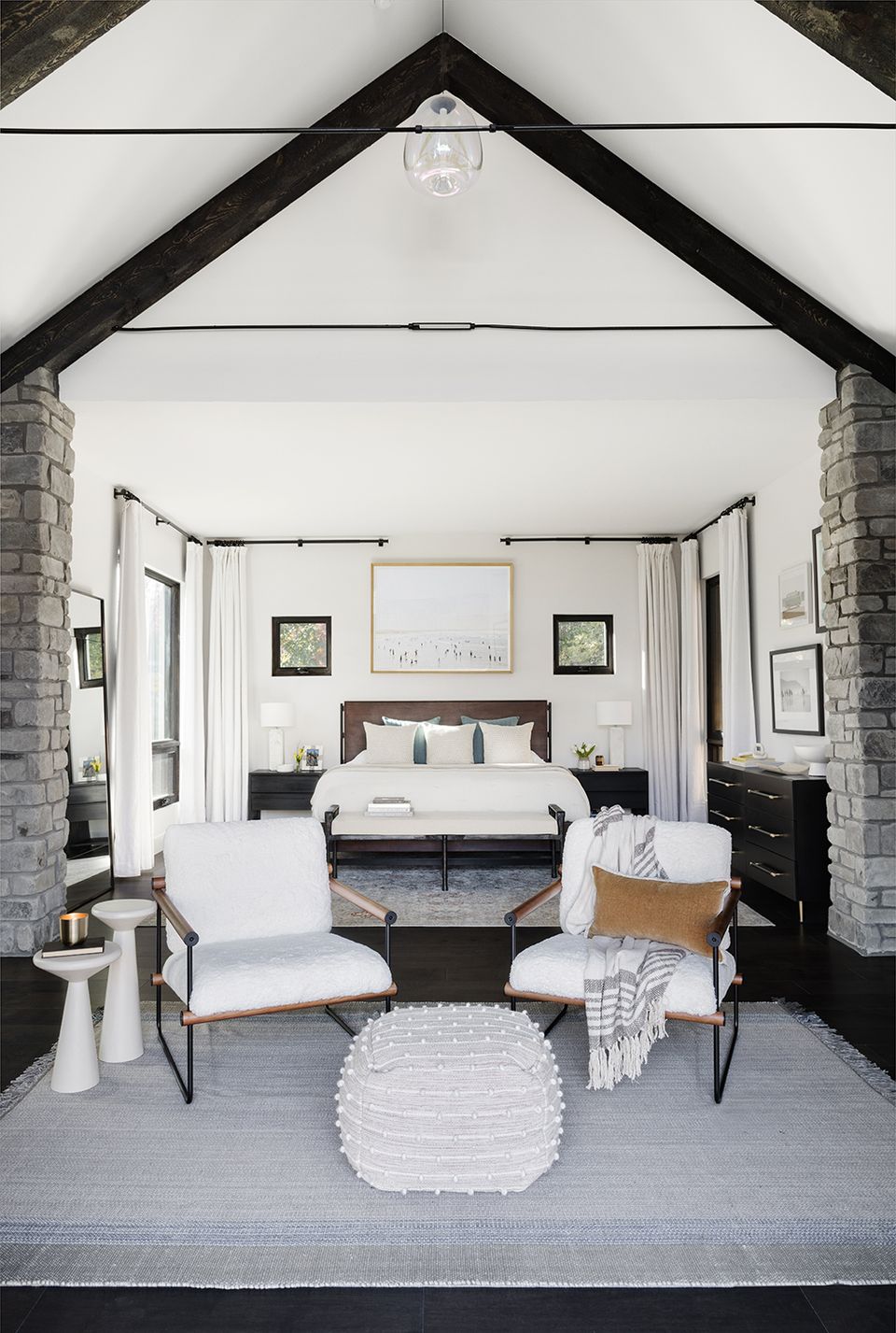 Modern farmhouse bedroom with vaulted ceilings, black-and-white palette, and contemporary minimalist furnishings