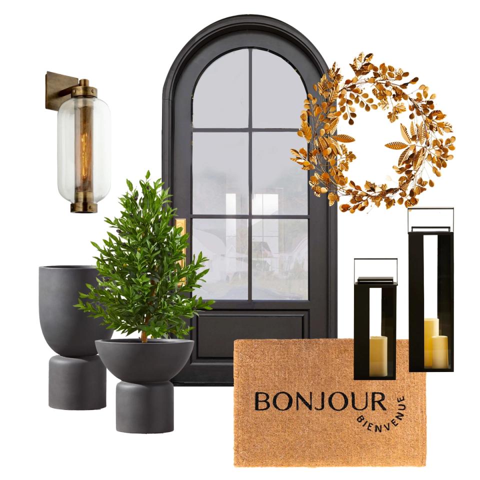 Eclectic front entrance with black arched door, golden leaf wreath, dark planters, and warm bronze accents