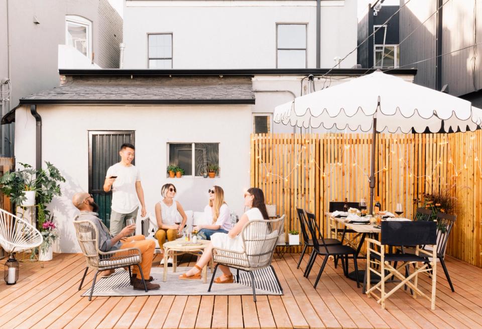 Modern farmhouse patio with warm wood tones, neutral furnishings, and harvest-inspired outdoor gathering space