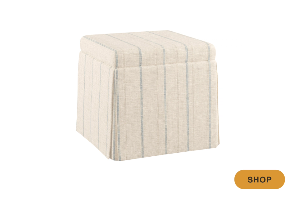 Cream striped upholstered ottoman with skirted base and neutral texture