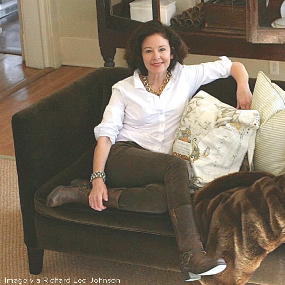 Classic living room with charcoal sofa, warm wood floors, and layered neutral textures in cream and olive tones