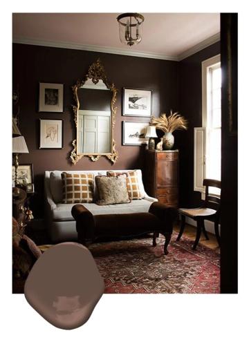 Moody chocolate brown den with ornate mirrors, jewel-toned accents, and vintage furnishings evoking classic, sophisticated elegance
