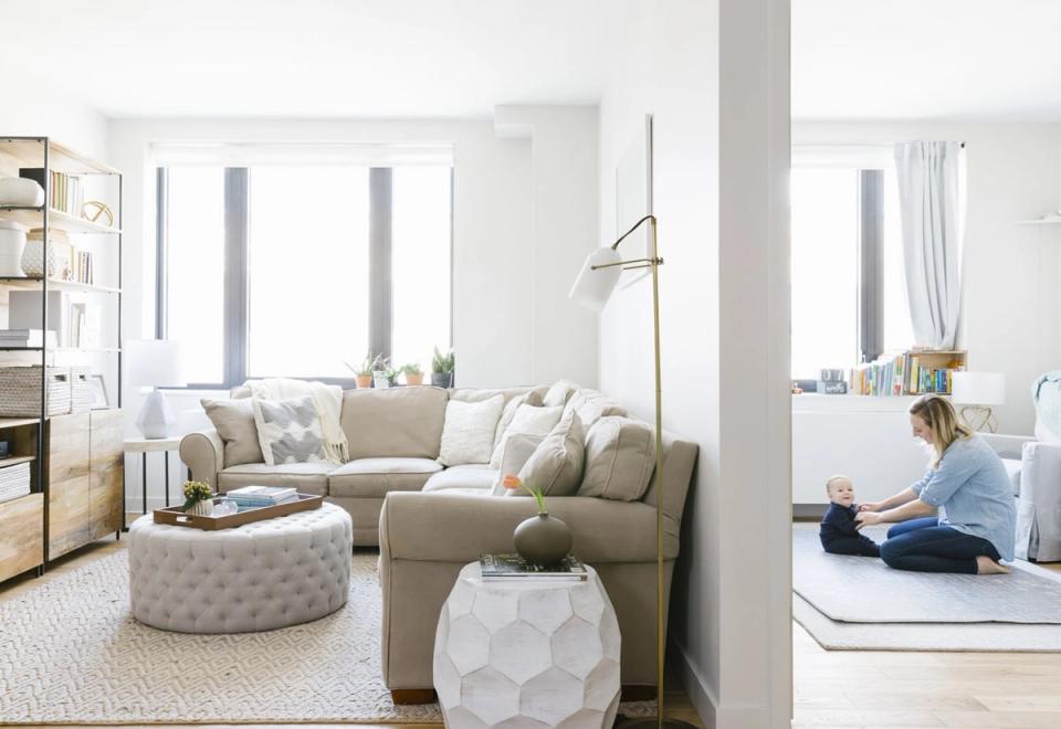 Bright minimalist studio with neutral beige palette, natural light, and multipurpose furniture creating open, airy living space