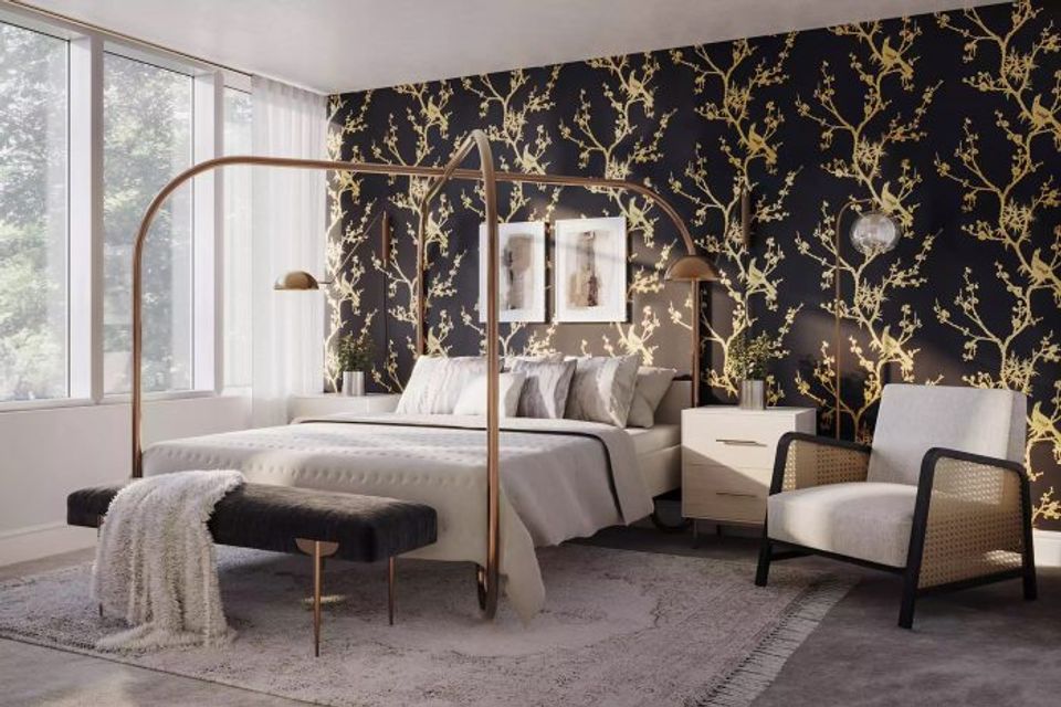 Luxe modern bedroom featuring black floral patterned accent wall, brass canopy bed, and neutral linens for elegant drama