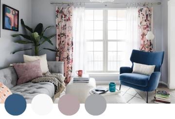 Eclectic bedroom with navy blue chair, pink floral curtains, soft gray walls, and botanical accent plants