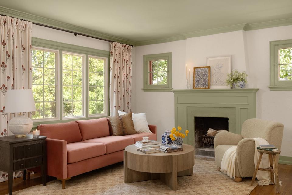 Bright traditional living room with coral sofa, fireplace, patterned curtains, and neutral palette
