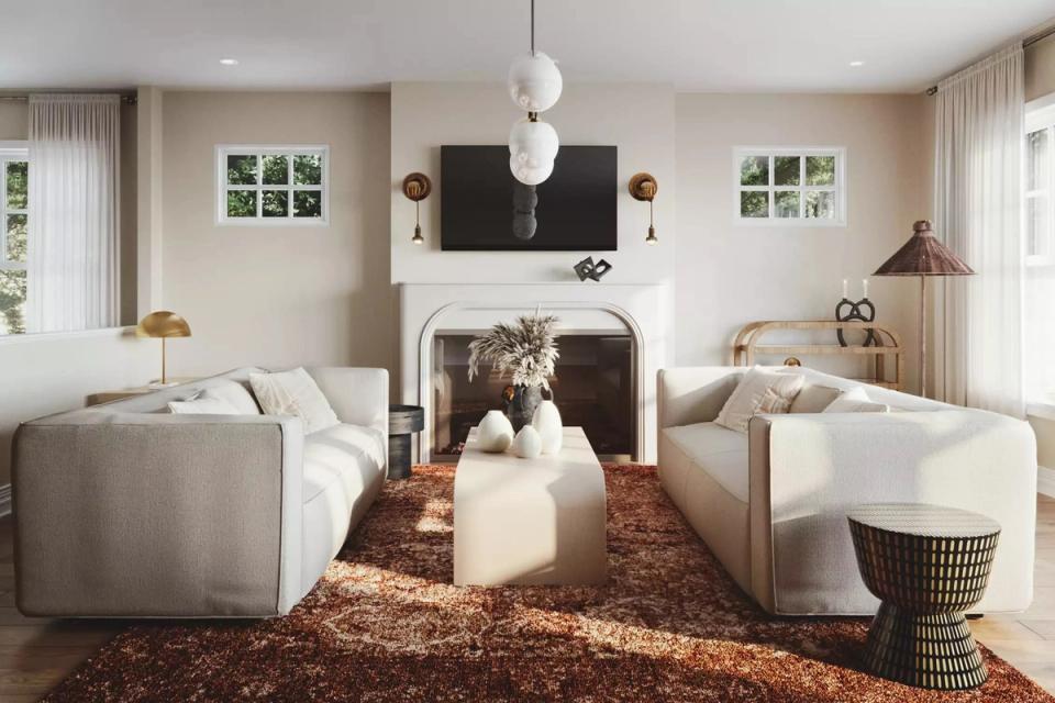 Warm transitional living room with cream seating, terracotta rug, black fireplace mantel, and vintage brass sconces