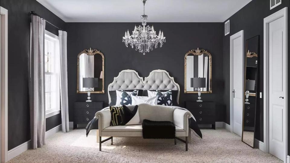 Glam dark academia bedroom with charcoal walls, crystal chandelier, and upholstered headboards