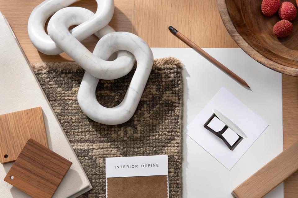 Photos, a tape measure, and inspiration images laid out to prepare for a design session