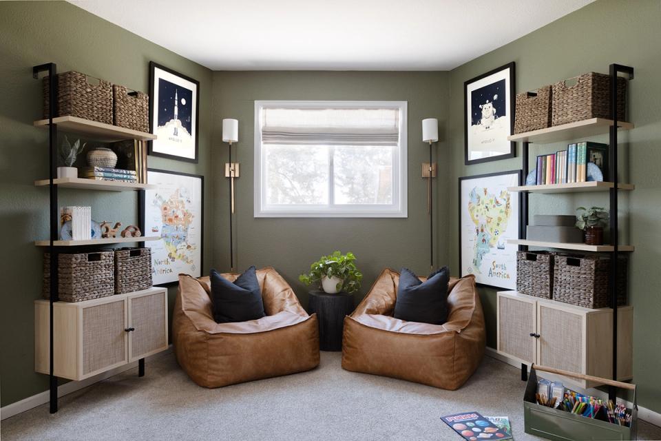 Serene sage-green lounge with cognac bean bags, built-in shelving, and minimalist décor