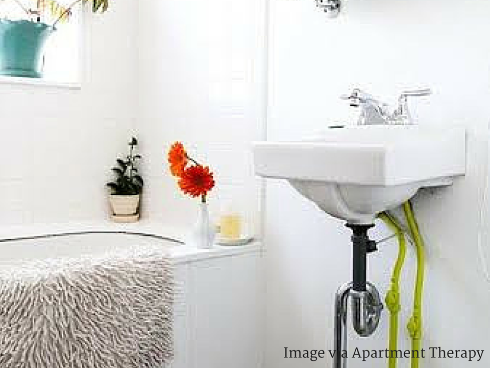 Minimalist bathroom with bright neon green plant hanger pop of color