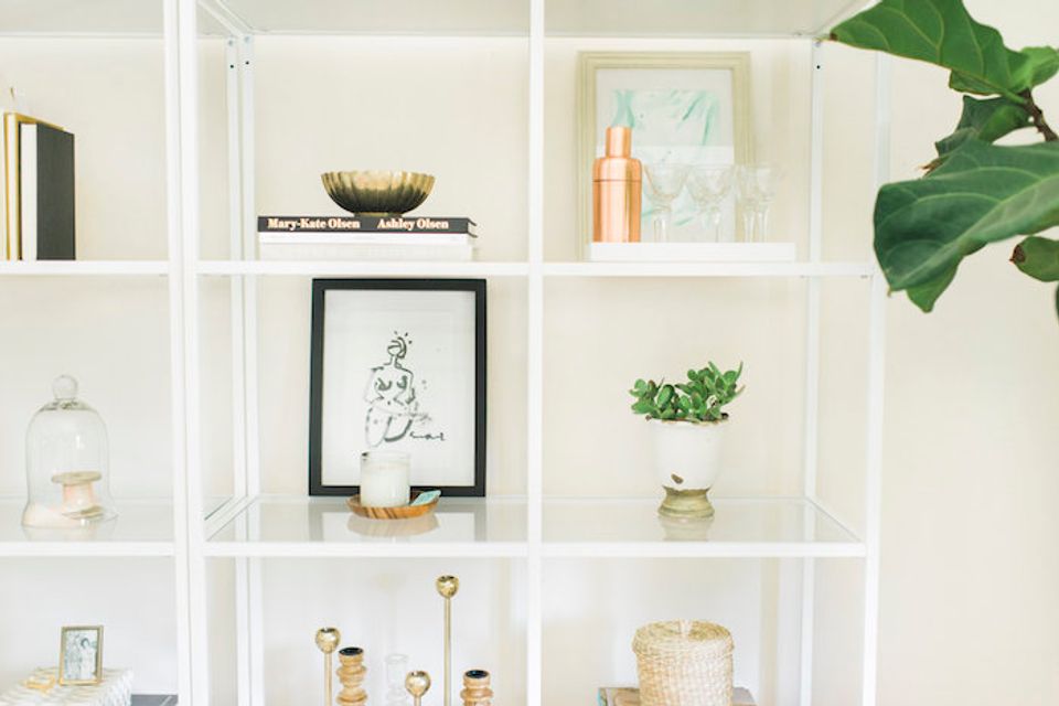 Bright white shelving unit with curated botanical, artwork, and natural wood accent pieces