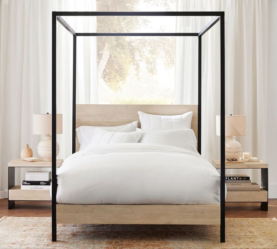 Contemporary wood and metal canopy bed with black frame in bright, modern bedroom