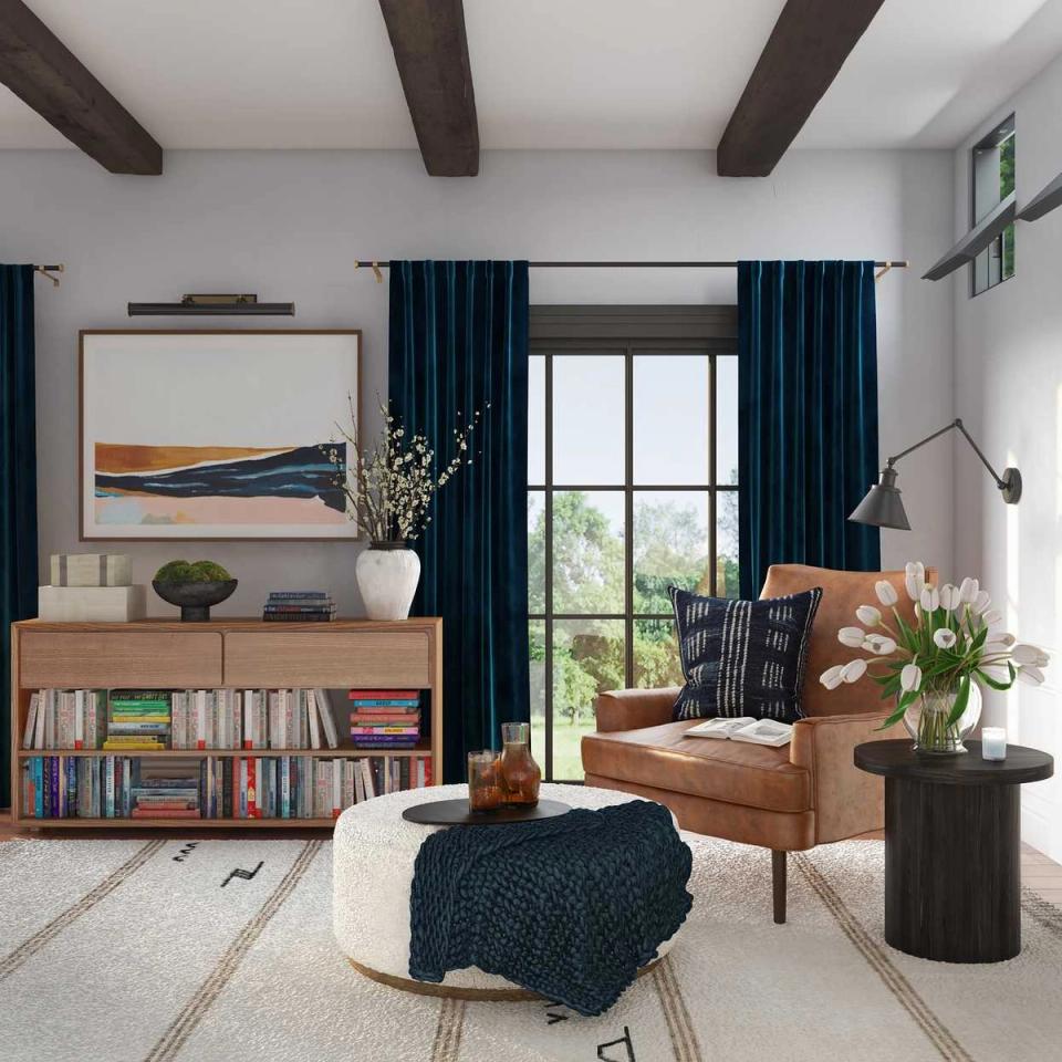 Modern mid-century reading room with cognac leather chair, navy curtains, and exposed beams