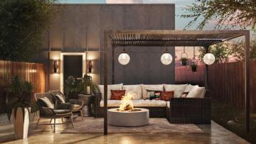Modern outdoor patio with warm pendant lighting, dark pergola, cozy seating, and ambient fire feature at dusk