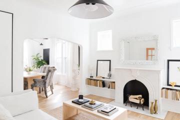 Light-filled Scandinavian interior with statement black fireplace and serene white aesthetic