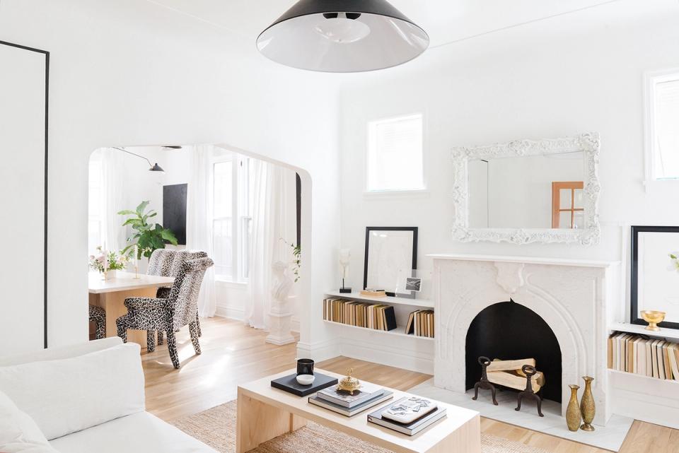 Light-filled Scandinavian interior with statement black fireplace and serene white aesthetic