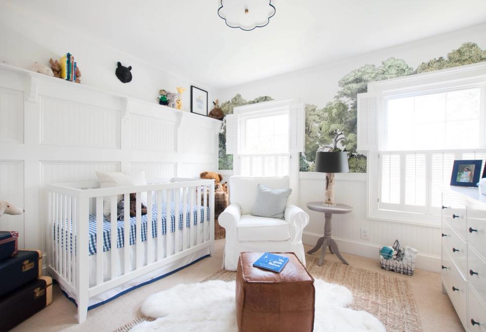 Serene coastal nursery with white crib, cream glider, natural wood accents, and soft blue bedding details