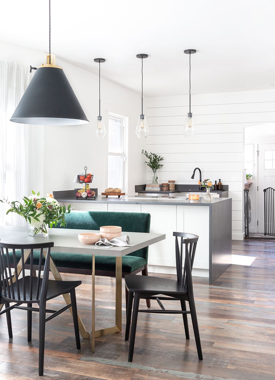 Scandinavian kitchen-dining space mixing matte black and brass metal accents